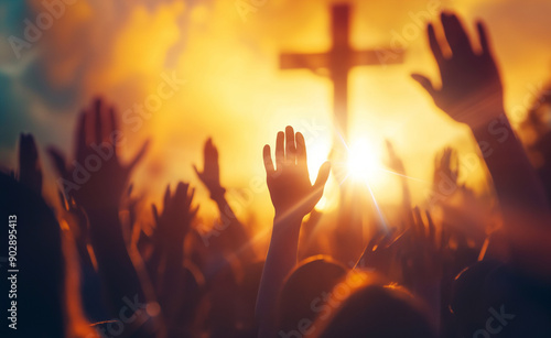People raising hands in worship during a sunset with a cross in the background. © Curioso.Photography