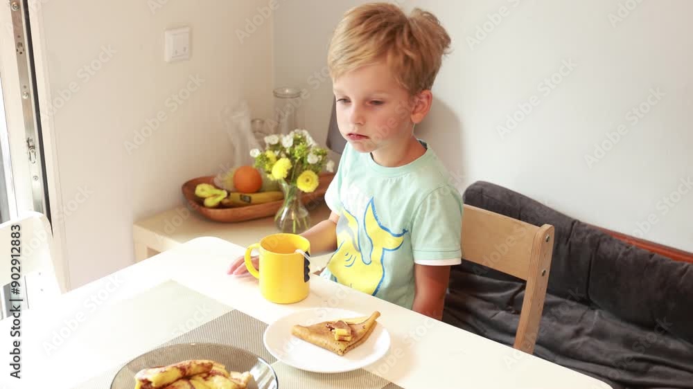 Caucasian Boy Enjoying Breakfast in the Kitchen at Home During Morning Hours Caucasian Boy Enjoying Breakfast in the Kitchen at Home During Morning Hours