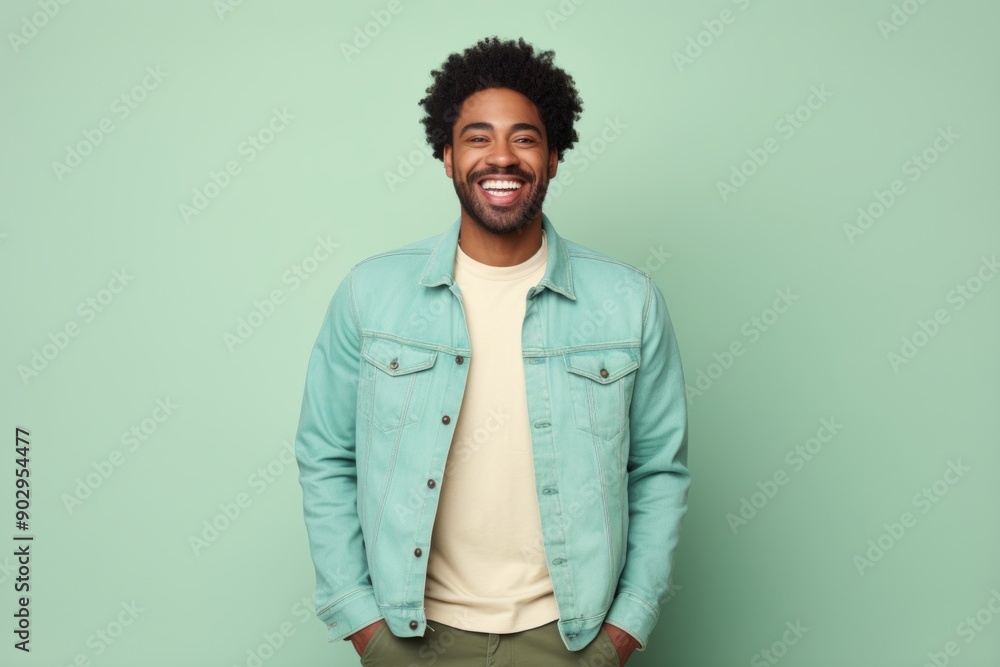 Portrait of a happy afro-american man in his 30s sporting a rugged denim jacket over pastel green background Portrait of a happy afro-american man in his 30s sporting a rugged denim jacket over pastel green background