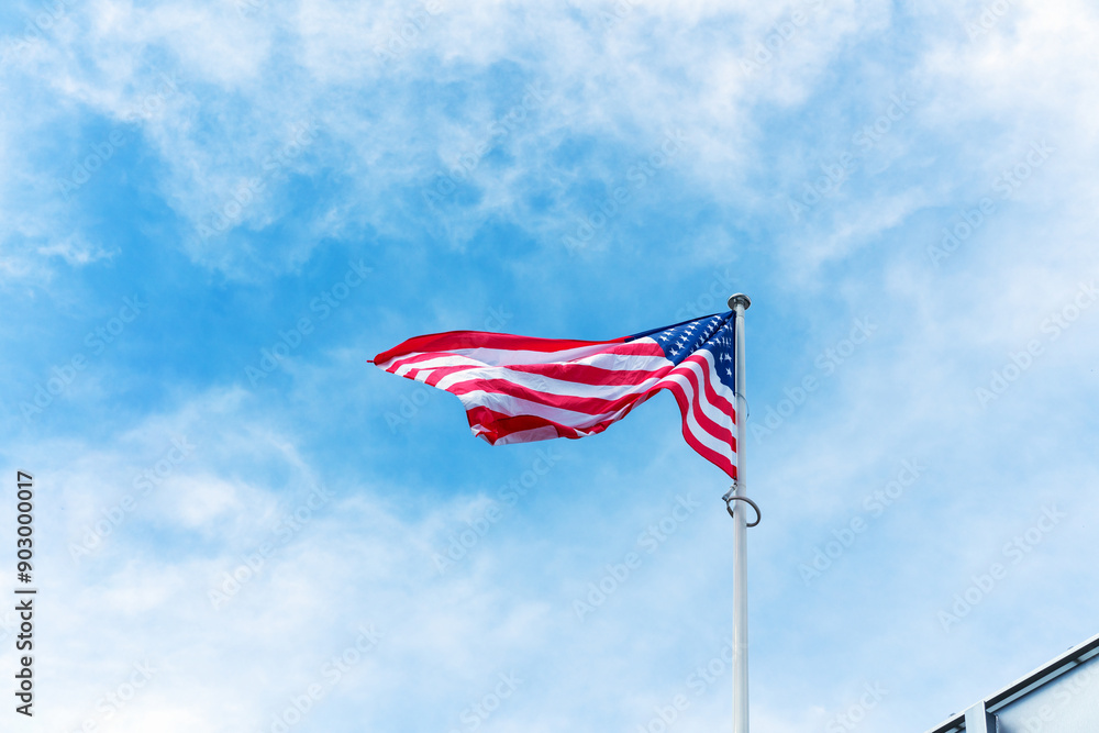 Low-angle view of the national flag of the United States of America waving on a flagpole Low-angle view of the national flag of the United States of America waving on a flagpole