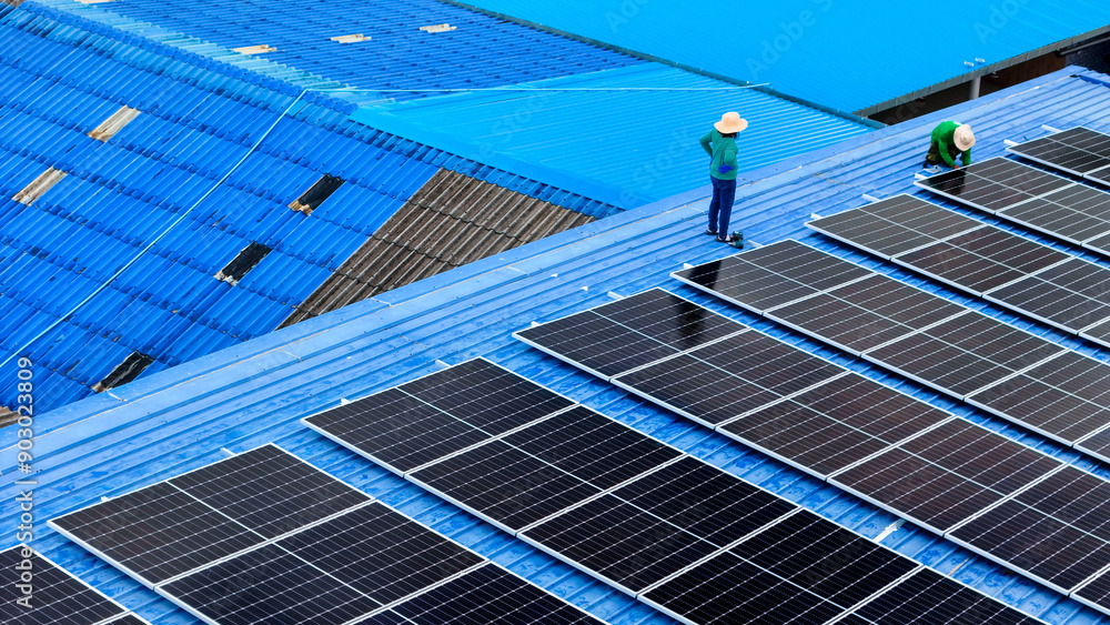 top aerial of engineer men inspects construction of solar cell panel or photovoltaic cell at roof top. Industrial Renewable energy of green power. factory at urban area. worker working on tower roof. top aerial of engineer men inspects construction of solar cell panel or photovoltaic cell at roof top. Industrial Renewable energy of green power. factory at urban area. worker working on tower roof.