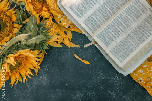 Foto Bible and sunflowers top view on black background