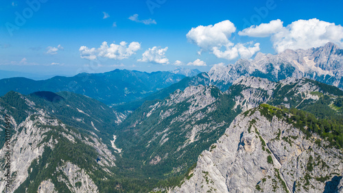 A stunning view of Slemenova Špica, showcasing a picturesque hiking trail in the Slovenian Alps. The image, captured from the air by a drone, highlights the breathtaking landscape, with rugged peaks  photo