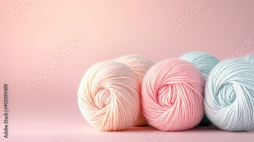  Three skeins of pastel-colored yarn on a light pink background