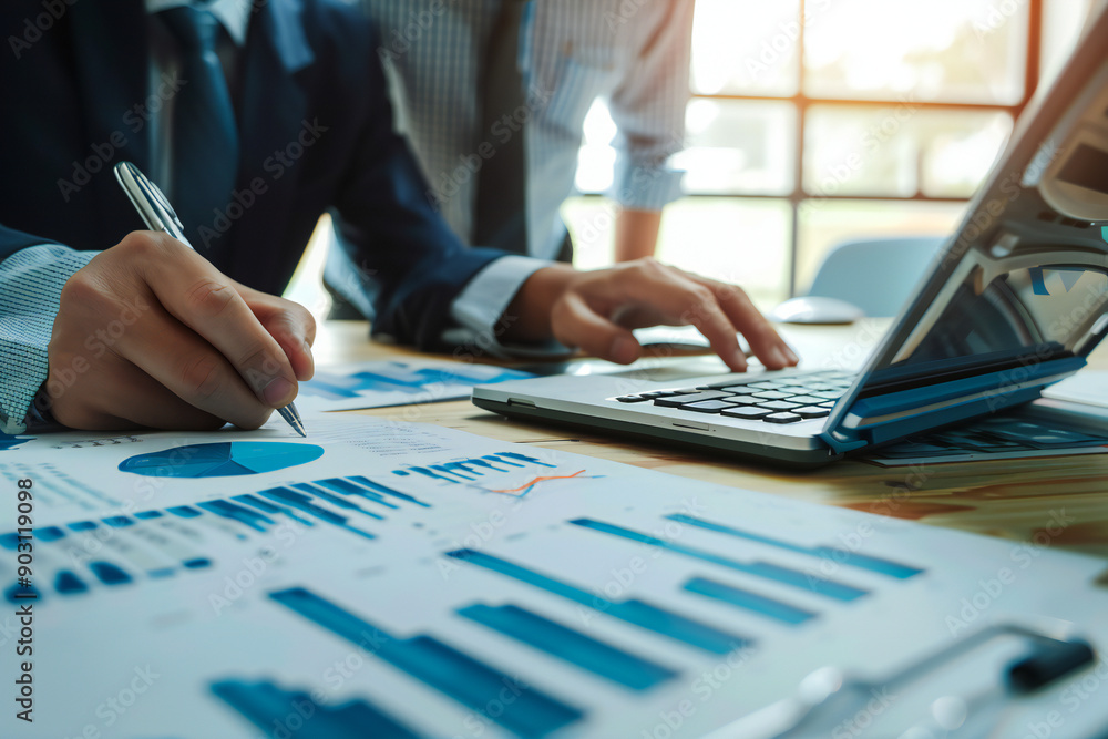 Detailed Financial Analysis with Charts and Laptop for Business Strategy and Productivity in Modern Office Detailed Financial Analysis with Charts and Laptop for Business Strategy and Productivity in Modern Office