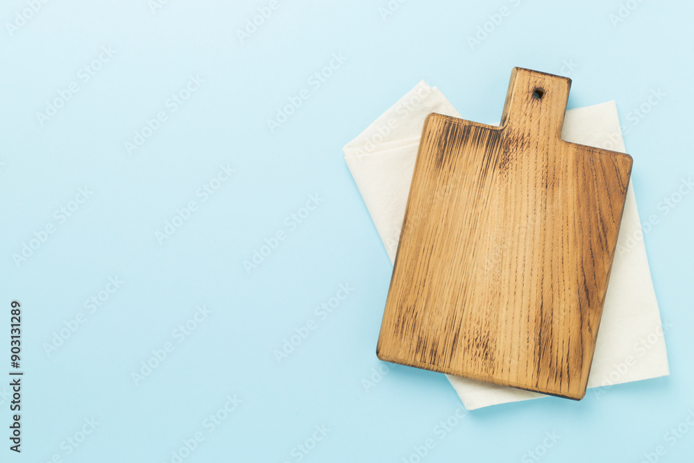 Cutting board with napkin on color background, top view Cutting board with napkin on color background, top view