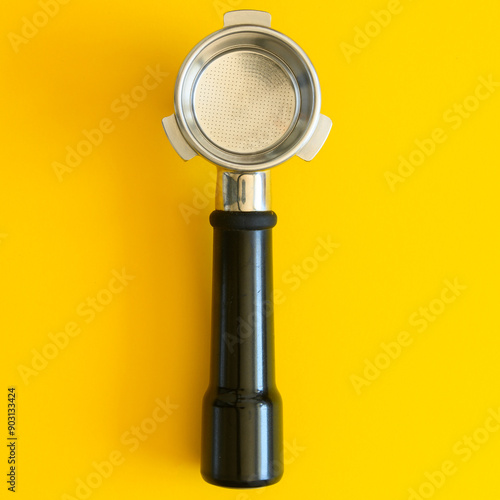 Foto Empty espresso portafilter on a yellow background