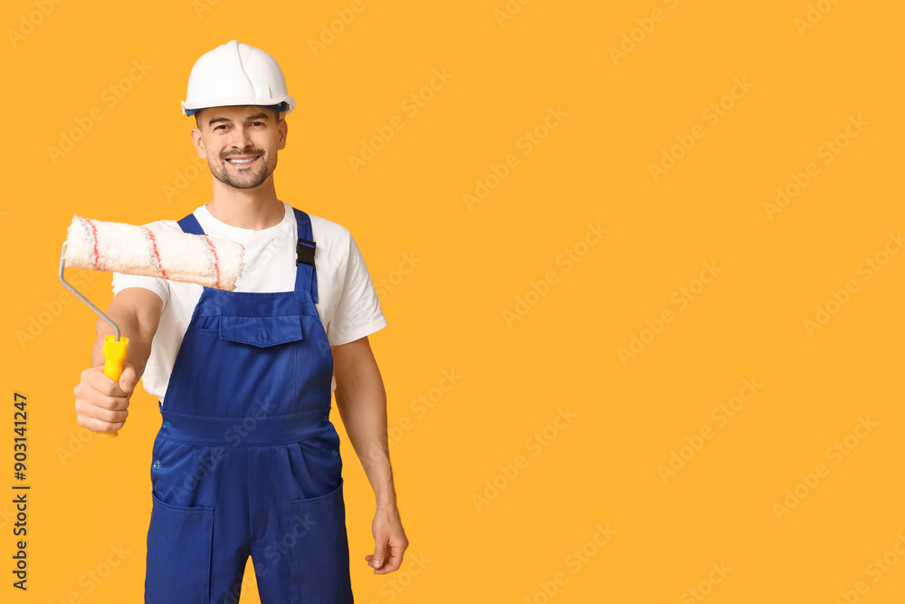 Portrait of male painter with paint roller on yellow background Portrait of male painter with paint roller on yellow background
