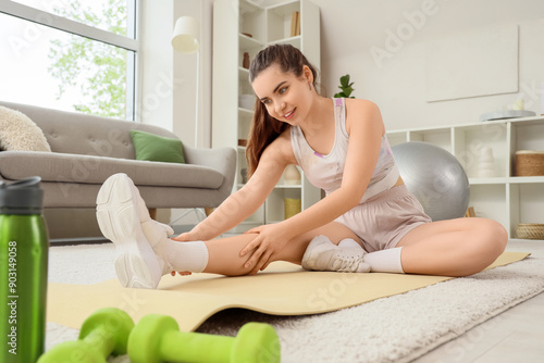 Young woman stretching legs...