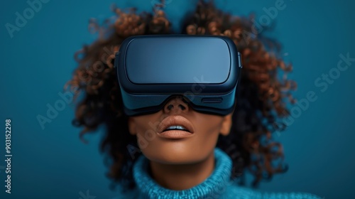 A person with a VR headset, standing against a deep blue background, symbolizing the futuristic and immersive nature of virtual reality technology in current times.