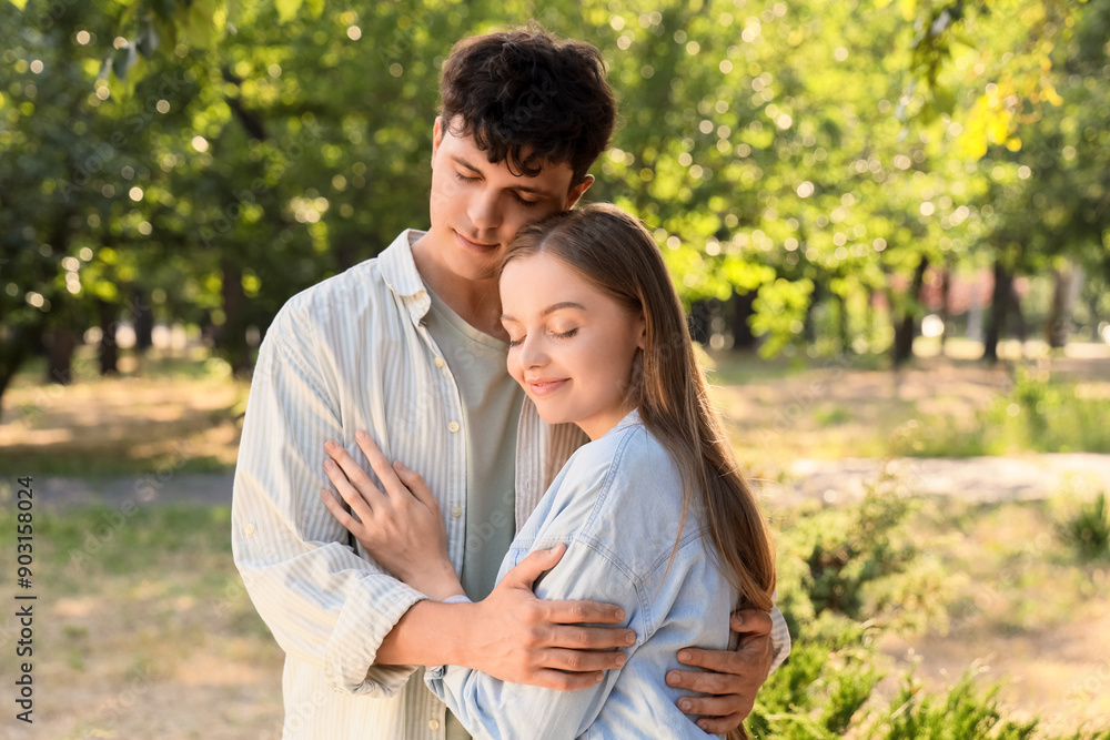 Beautiful young happy couple hugging in summer park Beautiful young happy couple hugging in summer park