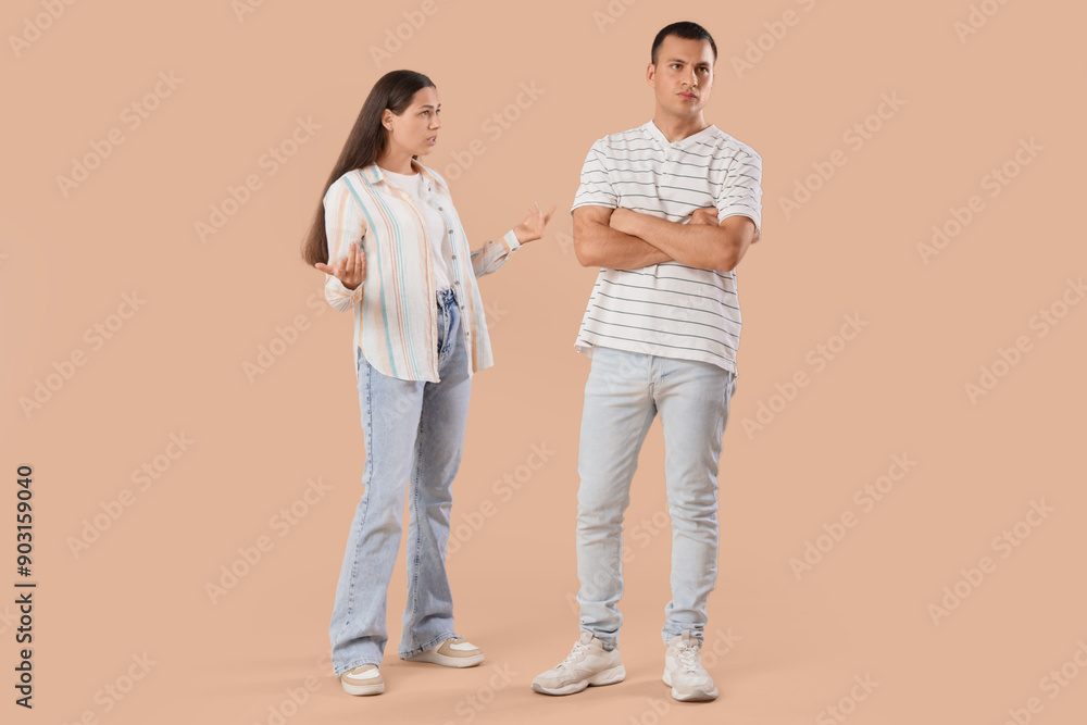 Young couple quarreling on beige background Young couple quarreling on beige background