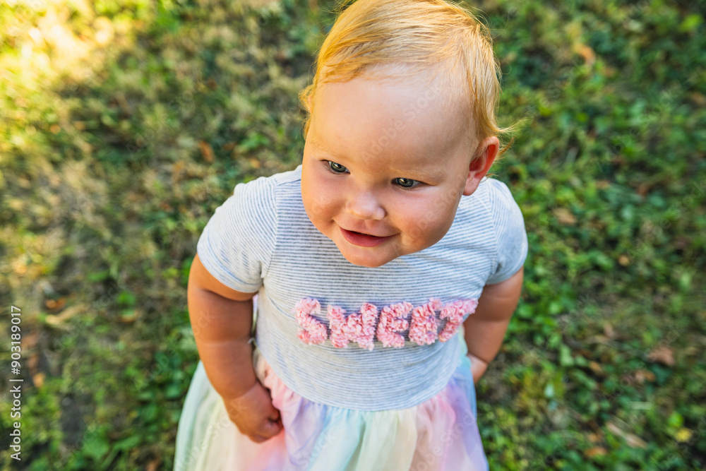Toddler Enjoys Sunny Day Outdoors Among Green Grass and Yellow Dandelions in Spring Toddler Enjoys Sunny Day Outdoors Among Green Grass and Yellow Dandelions in Spring