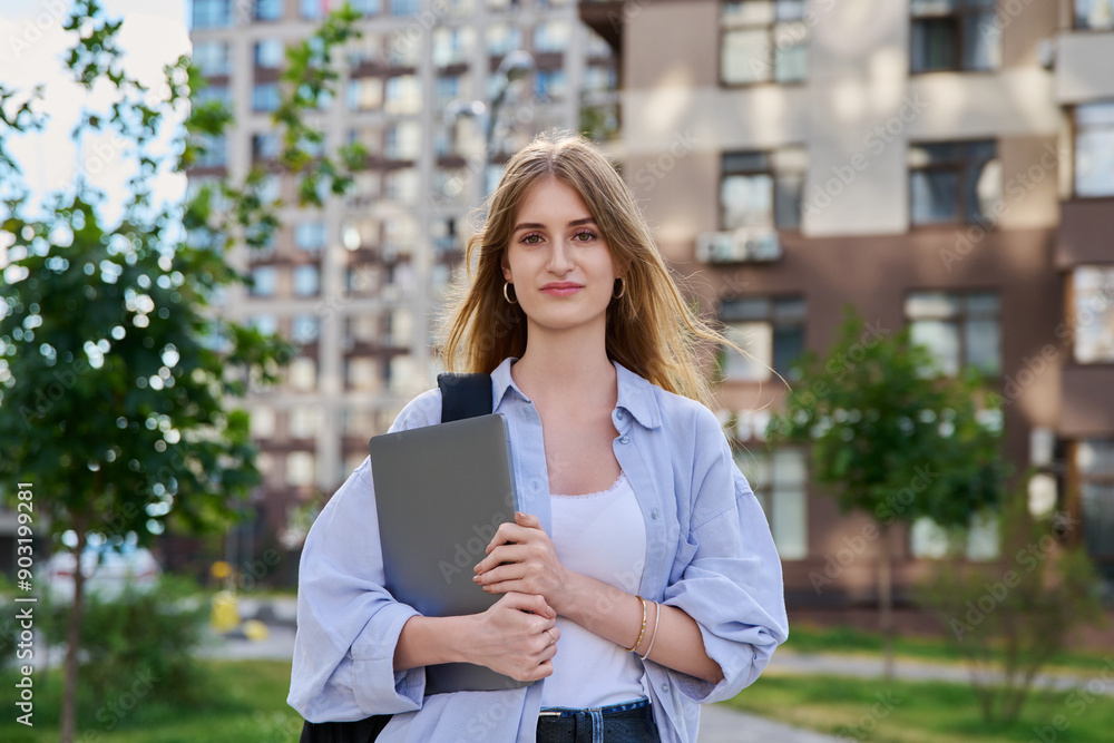 Portrait young female college student holding laptop computer outdoor Portrait young female college student holding laptop computer outdoor