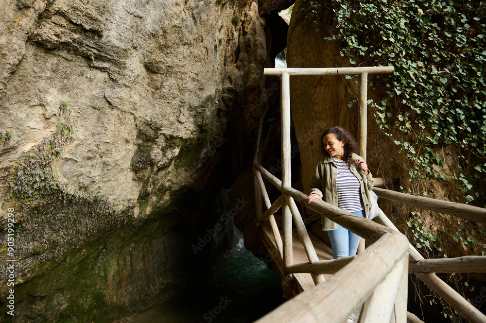 Woman exploring a scenic wooden walkway in a natural rocky canyon Woman exploring a scenic wooden walkway in a natural rocky canyon
