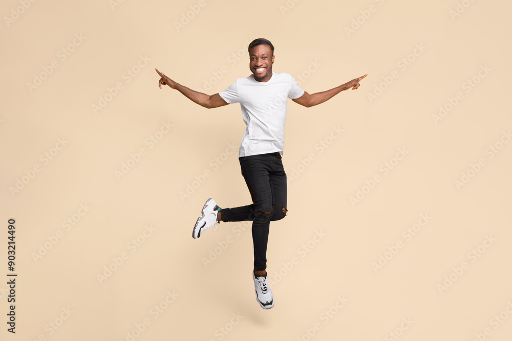 Cheerful Black Guy Jumping In Air Having Fun Posing Over Yellow Background. Studio Shot Cheerful Black Guy Jumping In Air Having Fun Posing Over Yellow Background. Studio Shot
