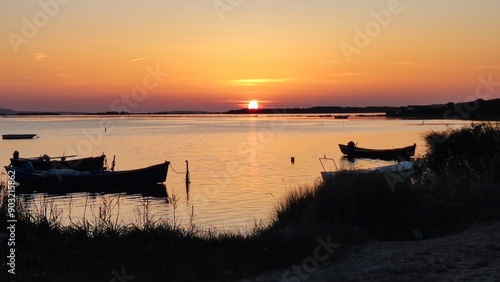 Tramonto al mare con barche ormeggiate photo