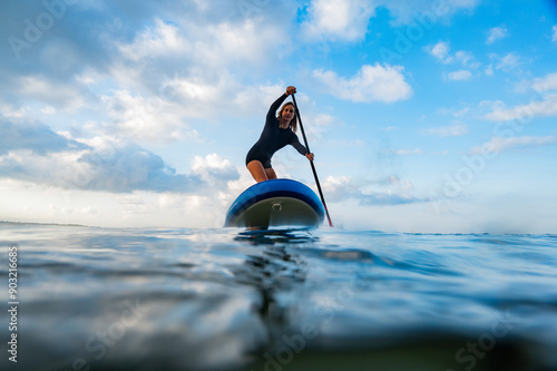 Young woman on the sea with a paddle surf board photo