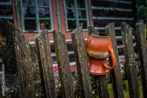 An old wooden fence with a clay pot. photo