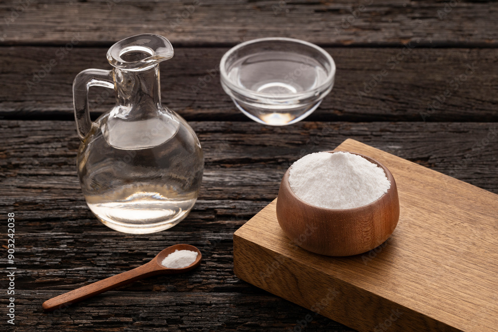 Vinegar in the glass jar and baking soda in the bowl Vinegar in the glass jar and baking soda in the bowl