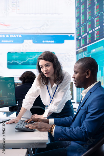 Enterprise colleagues reviewing project updates and details in monitoring room, establishing budget and other resources to achieve strategic business goals. Multiple corporation operations.