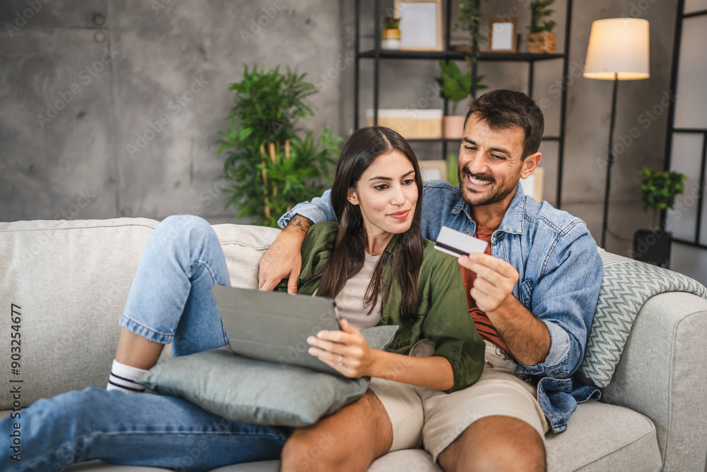Adult couple buy online on digital tablet with credit card at home Adult couple buy online on digital tablet with credit card at home