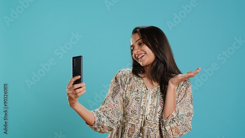 Photography Jolly indian woman smiling for selfies, posting them on social media using cellphone