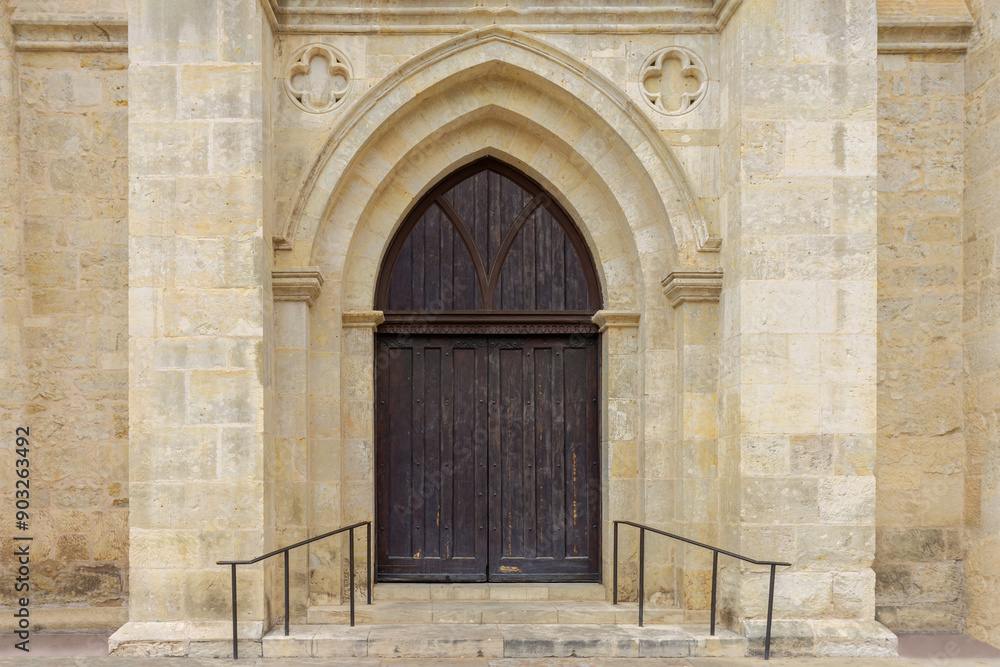 Exterior to an old christian church with wooden doors and stone brick walls Exterior to an old christian church with wooden doors and stone brick walls