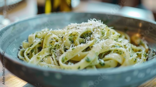 Fettuccine pasta with pesto sauce and parmesan cheese in grey bowl photo