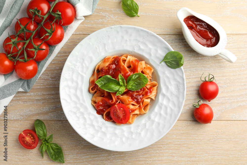 Delicious pasta with sauce, tomato and basil on wooden table, flat lay Delicious pasta with sauce, tomato and basil on wooden table, flat lay