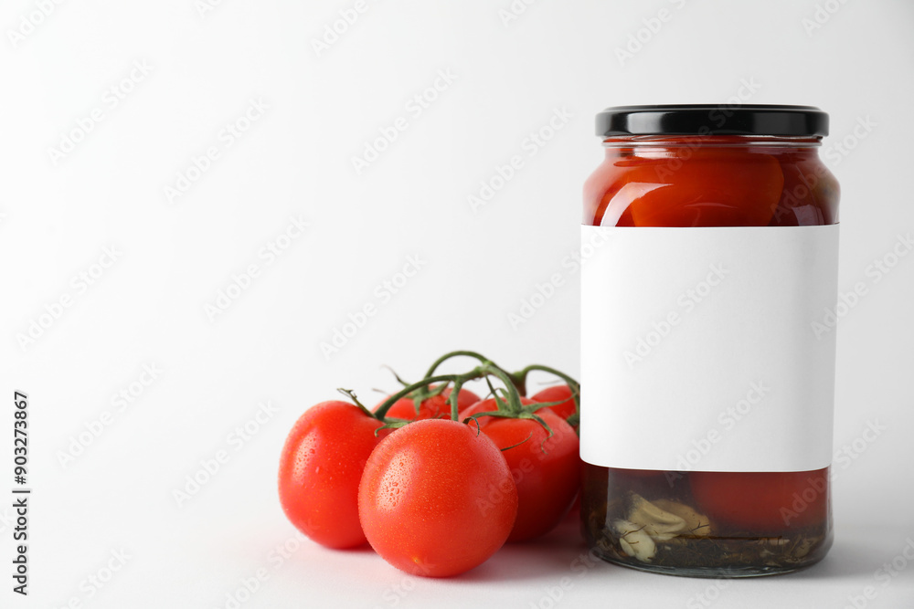 Tasty pickled tomatoes in jar and vegetables on light background, closeup. Space for text Tasty pickled tomatoes in jar and vegetables on light background, closeup. Space for text