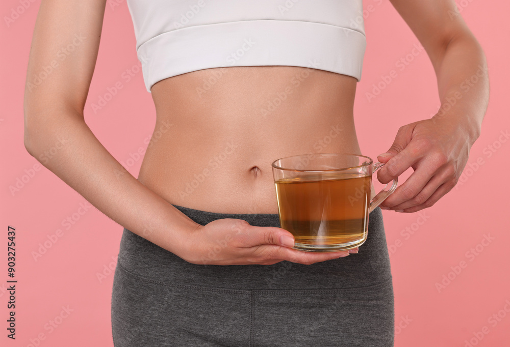 Weight loss concept. Woman with cup of diet tea on pink background, closeup Weight loss concept. Woman with cup of diet tea on pink background, closeup