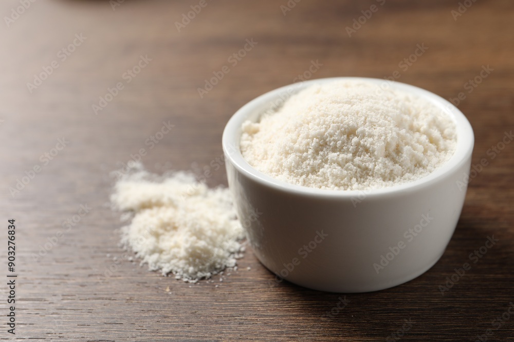 Organic coconut flour in bowl on wooden table, closeup Organic coconut flour in bowl on wooden table, closeup
