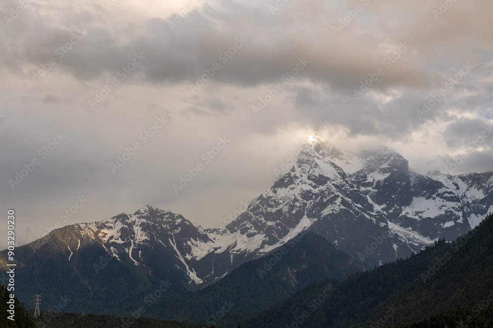 Fototapeta premium The snow-capped mountains are shrouded in clouds