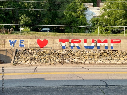 “We love Trump” painted in red, white and blue on a cement wall beside a highway. 
