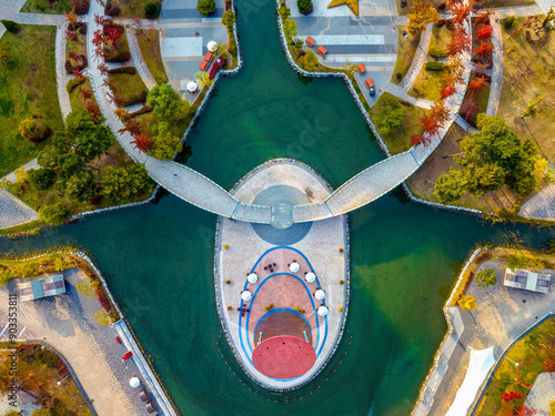 Seo-gu, Incheon, South Korea - October 28, 2022: Aerial and top angle view of maple trees with round trail and island on the lake of Canalway Waterside Park at Cheongna International City
 photo