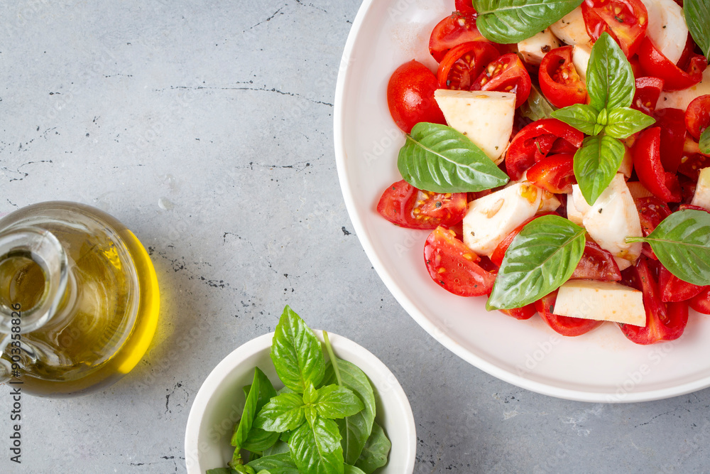 Italian caprese salad with sliced tomatoes, mozzarella, basil, olive oil