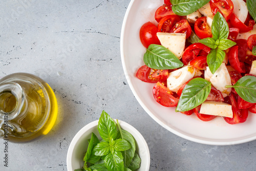 Obraz na płótnie Italian caprese salad with sliced tomatoes, mozzarella, basil, olive oil w salonie
