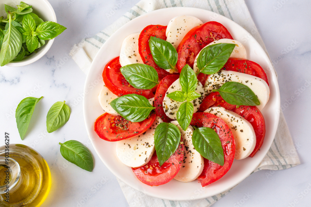 Italian caprese salad with sliced tomatoes, mozzarella, basil, olive oil