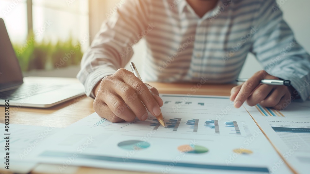 Focused Analysis: A close-up shot of a businessman's hand meticulously analyzing financial data with a pencil, showcasing the intricate details of a chart and graph. Focused Analysis: A close-up shot of a businessman's hand meticulously analyzing financial data with a pencil, showcasing the intricate details of a chart and graph.