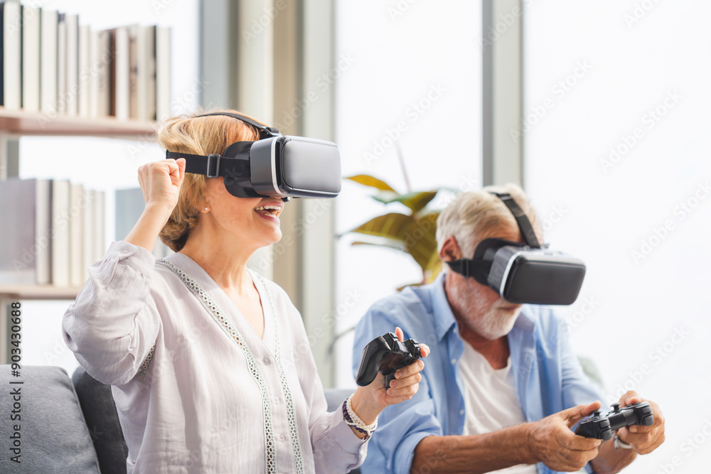 Man and woman playing games using virtual reality headset, Senior couple playing video game using virtual reality glasses and joystick Man and woman playing games using virtual reality headset, Senior couple playing video game using virtual reality glasses and joystick