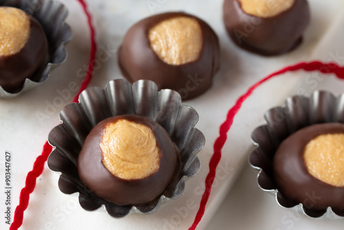 Smooth and Creamy Buckeye Chocolate and Peanut Butter Candies / Chocolates on White Background with red ribbon