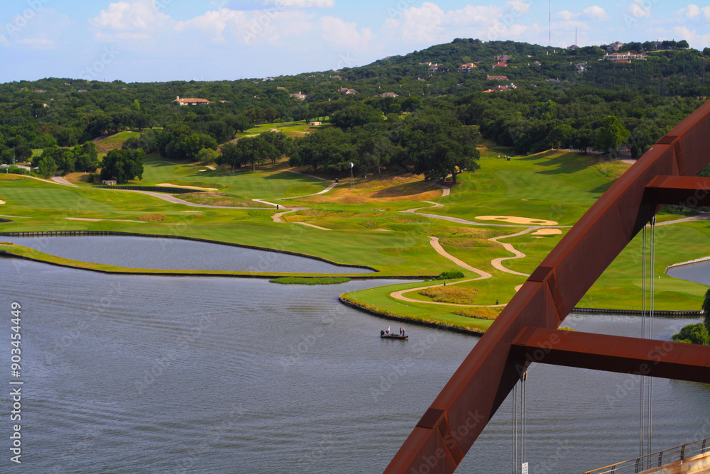 Fototapeta premium A calm lake and a maze of cart paths border the expansive golf course at the foot of the hills. It is a scenic haven for golfers and nature lovers alike.