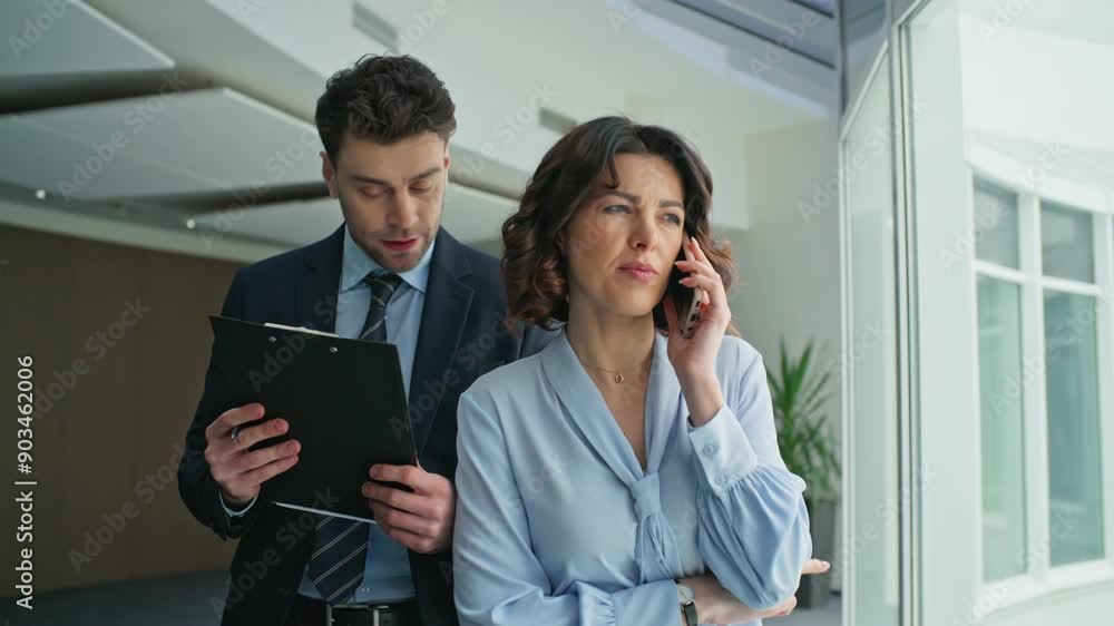 Woman ceo talking mobile phone walking office hallway with man secretary closeup Woman ceo talking mobile phone walking office hallway with man secretary closeup