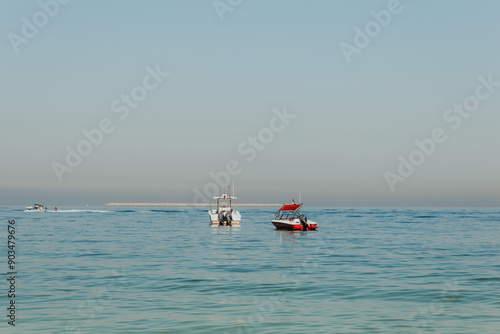 Boats anchored on calm sea with a distant horizon