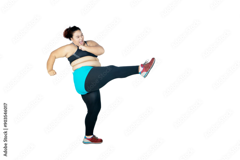 Fat Asian amused women wearing sportswear while kicking the air, isolated in white background Fat Asian amused women wearing sportswear while kicking the air, isolated in white background