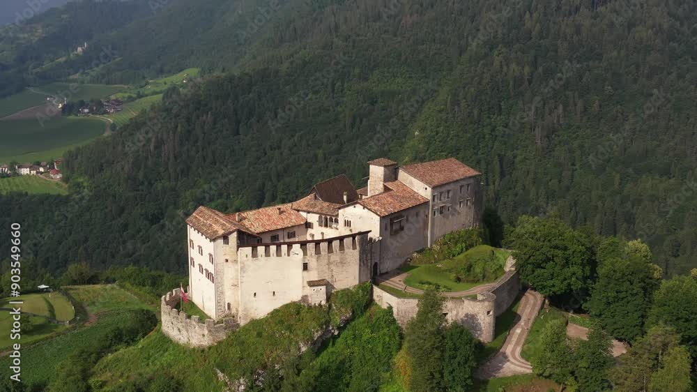 Slow flight point of interest Castle of Stenico. Rio bianco natural area waterfall in the background. Drone view of Castello di Stenico, a medieval fortress in northern Italy. Slow flight point of interest Castle of Stenico. Rio bianco natural area waterfall in the background. Drone view of Castello di Stenico, a medieval fortress in northern Italy.