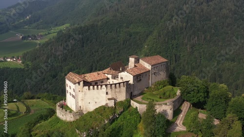 Slow flight point of interest Castle of Stenico. Rio bianco natural area waterfall in the background. Drone view of Castello di Stenico, a medieval fortress in northern Italy. photo