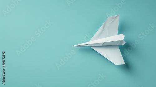 origami-style paper plane flying across a plain sky blue background