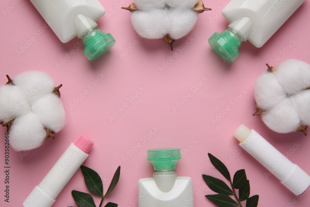 Different cosmetic products, leaves and cotton flowers on pink background, flat lay. Space for text Different cosmetic products, leaves and cotton flowers on pink background, flat lay. Space for text